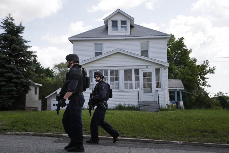 Law enforcement officers walk the streets near the prison in Dannemora, N.Y., as they searched houses near the maximum-security prison in northern New York where two killers escaped using power tools, June 10, 2015.