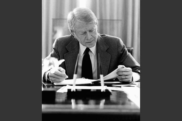 President Jimmy Carter reads over documents in his office in Washington, D.C. on Mar. 24, 1979 (Photo by Corbis).