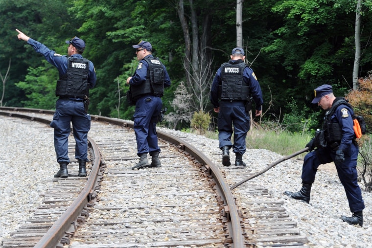 New York State Department of Corrections officers search the railroad tracks after a possible sighting of the two murder convicts who escaped from a northern New York prison two weeks ago June 21, 2015, in Friendship, N.Y. (Photo by Gary Wiepert/AP)