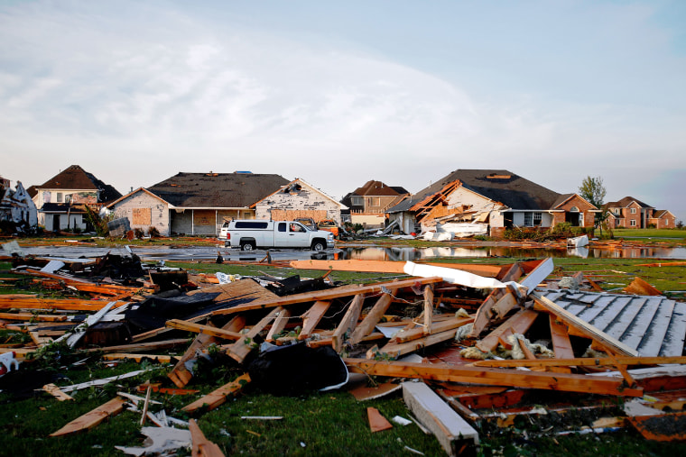 A pickup truck drives through a flooded roadway on W Daisy Place after a tornado struck the previous day on June 23, 2015 in Coal City, Illinois. (Photo by Jon Durr/Getty)