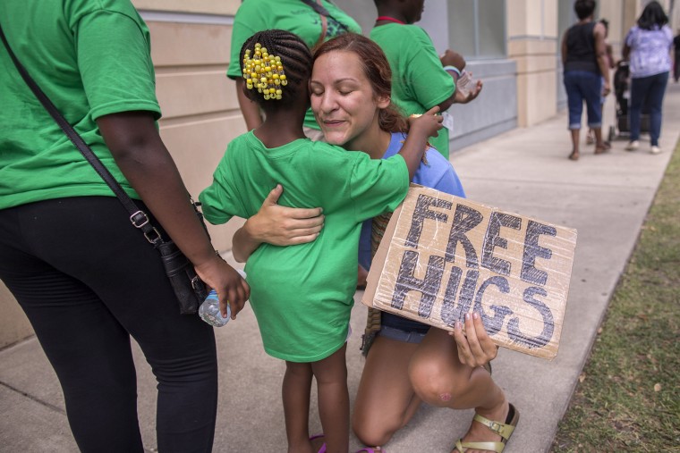 Sharry Schuller of Charleston give out free hugs to anyone who wants one while visiting the memorial in front of the Emanuel AME Church, June 20, 2015, in Charleston, S.C. (Photo by Stephen B. Morton/AP)