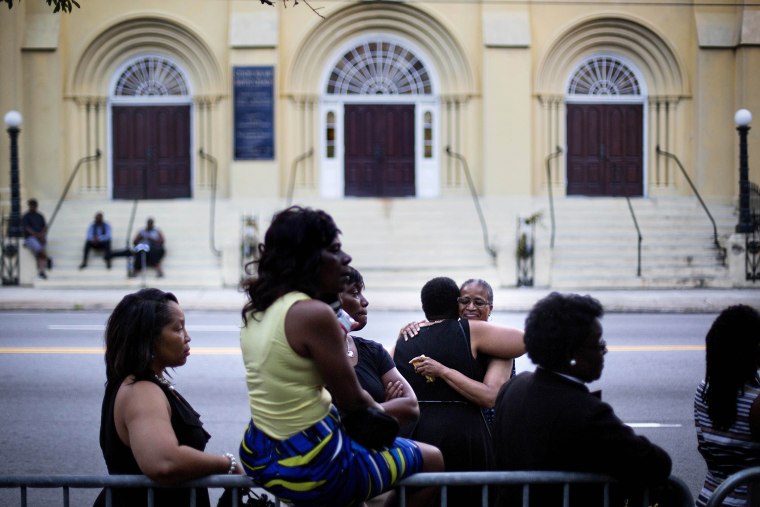 Lauretta Geddis, of Charelston, S.C., rear right, embraces Brenda T. Williams, of North Charelston, while waiting on line to enter Sen. Clementa Pinckney's funeral service, June 26, 2015, in Charleston. (Photo by David Goldman/AP)