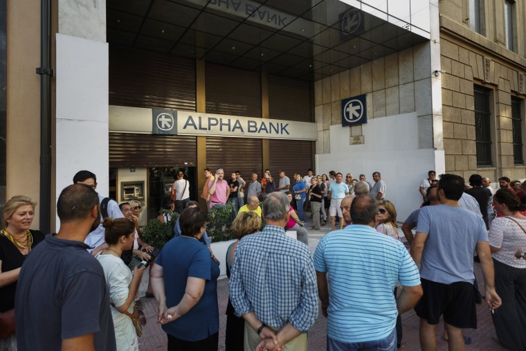 People stand in a queue to use ATM cash machine of a bank in central Athens on June 28, 2015. (Photo by Daniel Ochoa de Olza/AP)