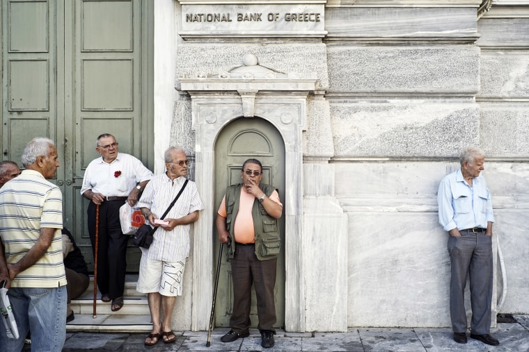 Pensioners stand outside of a branch of the National Bank of Greece hoping to draw their pensions on June 29, 2015 in Athens, Greece. (Photo by Milos Bicanski/Getty)