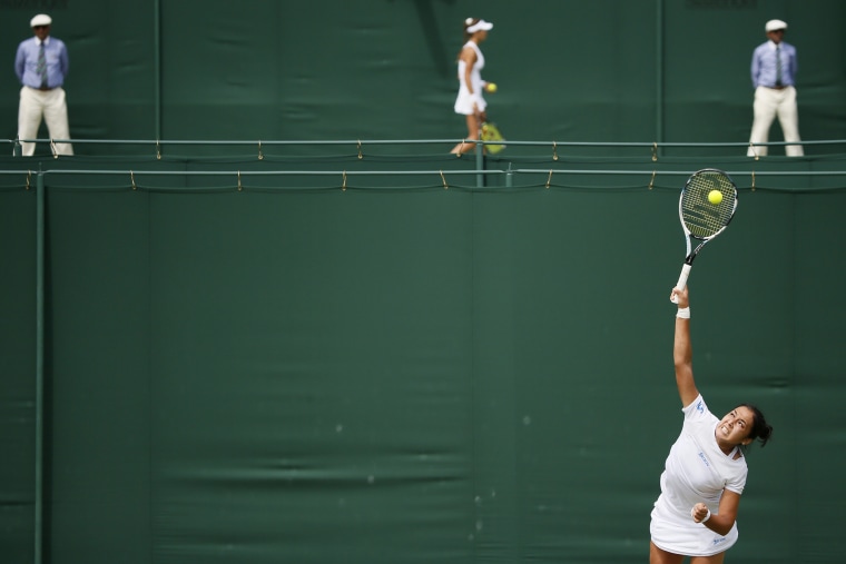 Zarina Diyas of Kazakhstan (foreground) serves during her match against Flavia Pennetta of Italy as Vitalia Diatchenko of Russia looks on during her match against Anna-Lena Friedsam of Germany at the Wimbledon Tennis Championships in London, June 29, 2015