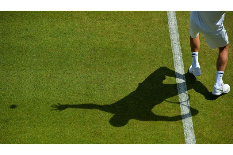 Serbia's Novak Djokovic's training partner serves to him during a practice session on day one of the 2015 Wimbledon Championships at The All England Tennis Club in Wimbledon, southwest London, on June 29, 2015. (Photo by Glyn Kirk/AFP/Getty)