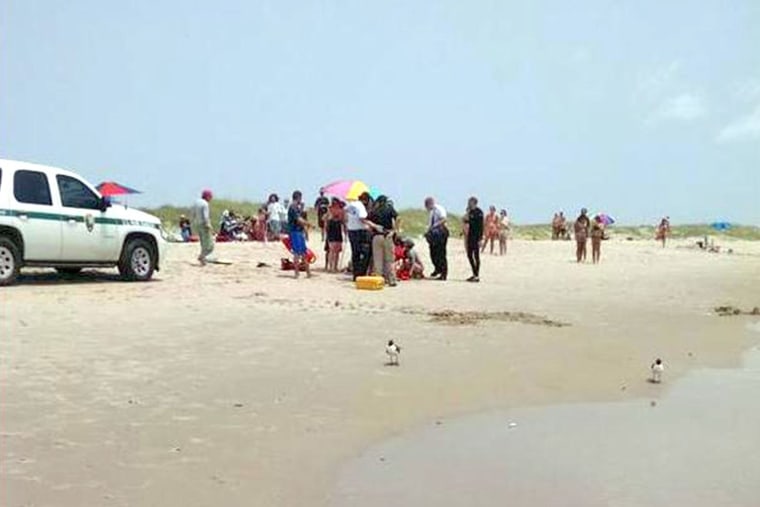 A man is treated on the beach after being attacked by a shark off Ocracoke Island in N.C. on July 1, 2015. (Photo by Jackson Fuqua)