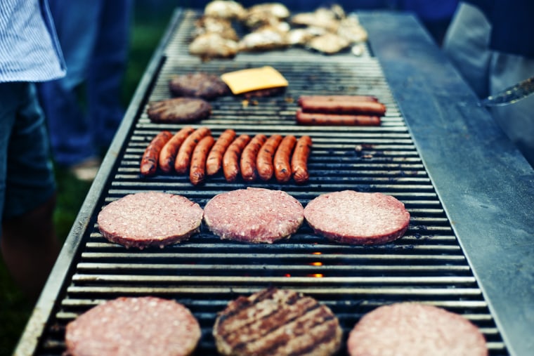 American barbecue scene with hamburgers and hot dogs on the grill (Photo by Gabriela Herman/Gallery Stock).