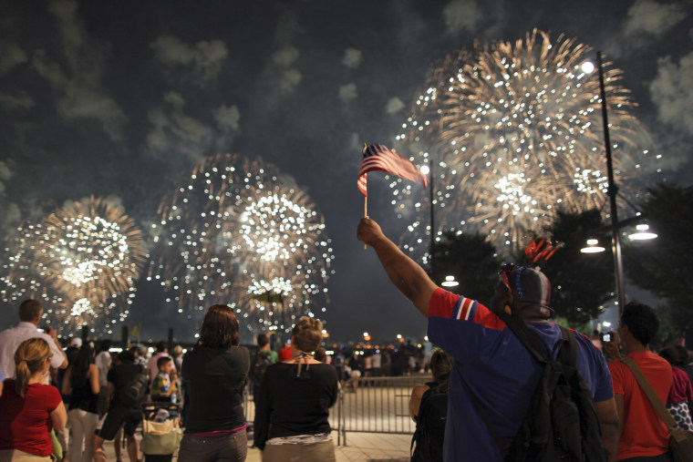 Karim Simmons, of the Bronx, waves an American flag while watching the fireworks explode over the Hudson river during Macy's annual fireworks display on July 4, 2009 in New York.