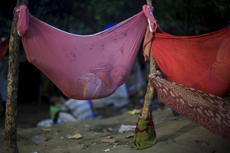 A girl lies in a hammock at a slum area in New Delhi, India on Apr. 12, 2015 (Photo by Adnan Abidi/Reuters)