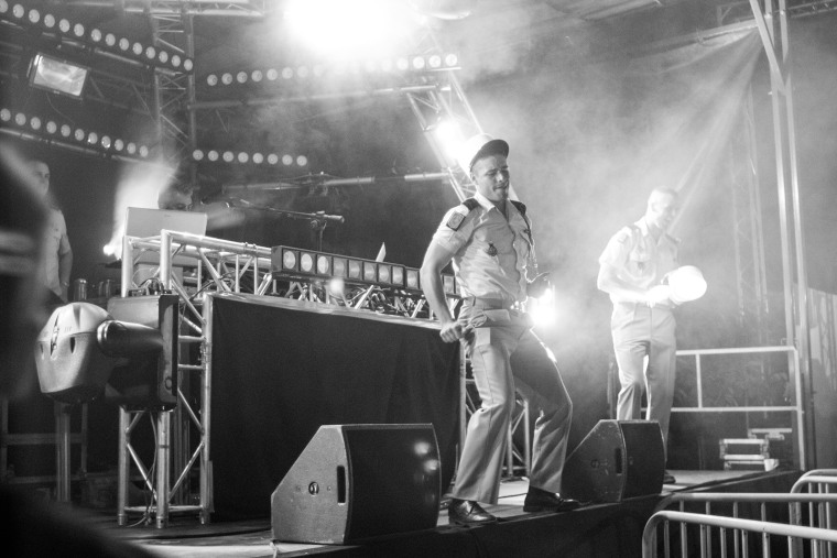 Officers dance on stage at a Fireman's ball during Bastille Day in Paris (Photo by Caroline Silber).