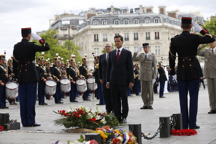 Mexican President Enrique Pena Nieto (c) and French Finance Minister Michel Sapin (Rear L) attend a wreath laying ceremony on the tomb of the unknown soldier at the Arc de Triomphe monument (Photo by Thomas Samson/AFP/Getty).
