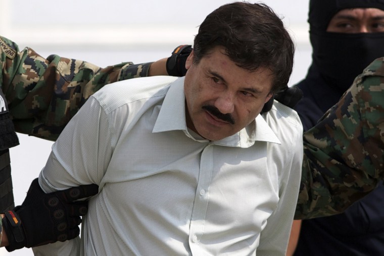 Joaquin \"El Chapo\" Guzman is escorted to a helicopter in handcuffs by Mexican navy marines at a navy hanger in Mexico City, Feb. 22, 2014. (Photo by Eduardo Verdugo/AP)