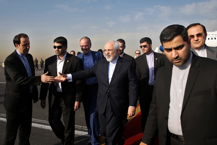 Iran's Foreign Minister Mohammad Javad Zarif, who is also Iran's top nuclear negotiator, center, shakes hands with an official upon arrival at the Mehrabad airport in Tehran, Iran, July 15, 2015. (Photo by Ebrahim Noroozi/AP)