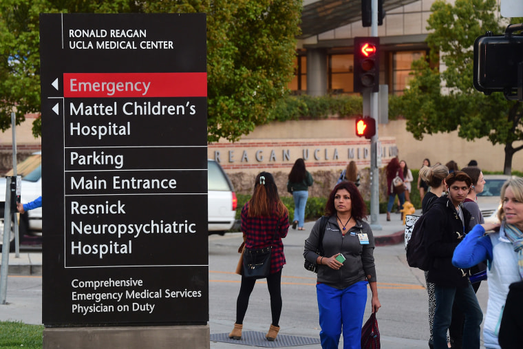 Pedestrians and students watch media gathered outside the Ronald Reagan UCLA Medical Center in Los Angeles, Calif. on March 5, 2015. (Photo by Frederic J. Brown/AFP/Getty)