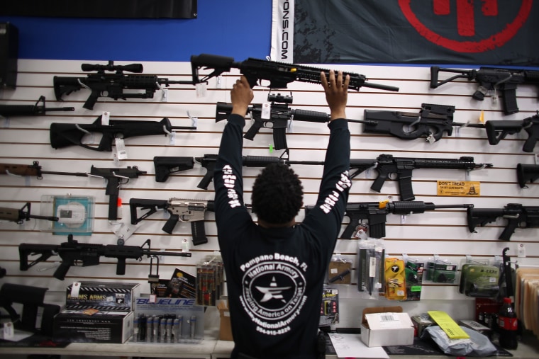 A man puts a weapon on display (Photo by Joe Raedle/Getty).