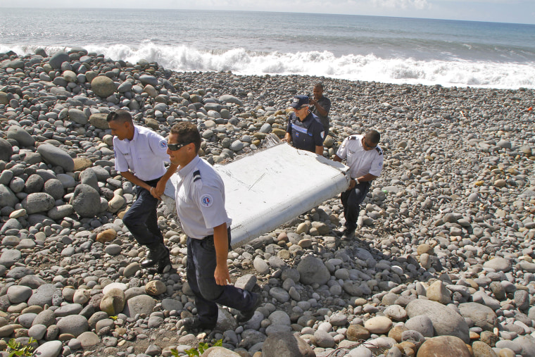 In this photo dated July 29, 2015, French police officers carry a piece of debris from a plane in Saint-Andre, Reunion Island. (Photo by Lucas Marie/AP)