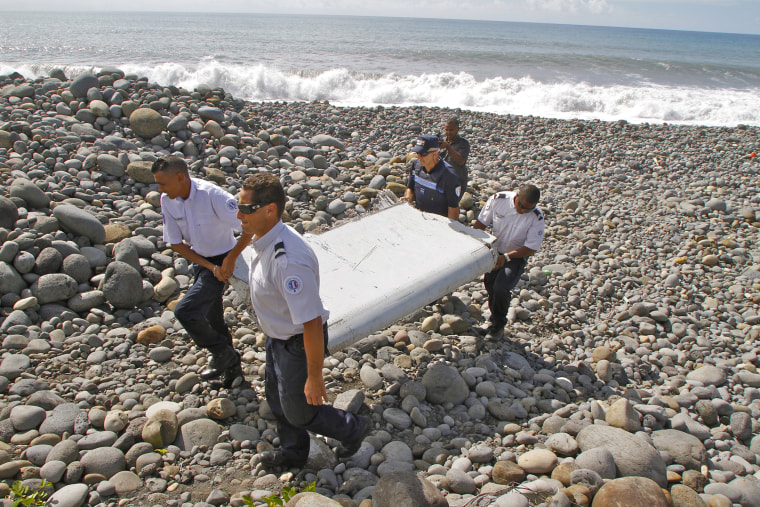 French police officers carry a piece of debris from a plane in Saint-Andre, Reunion Island (Photo by Lucas Marie/AP).