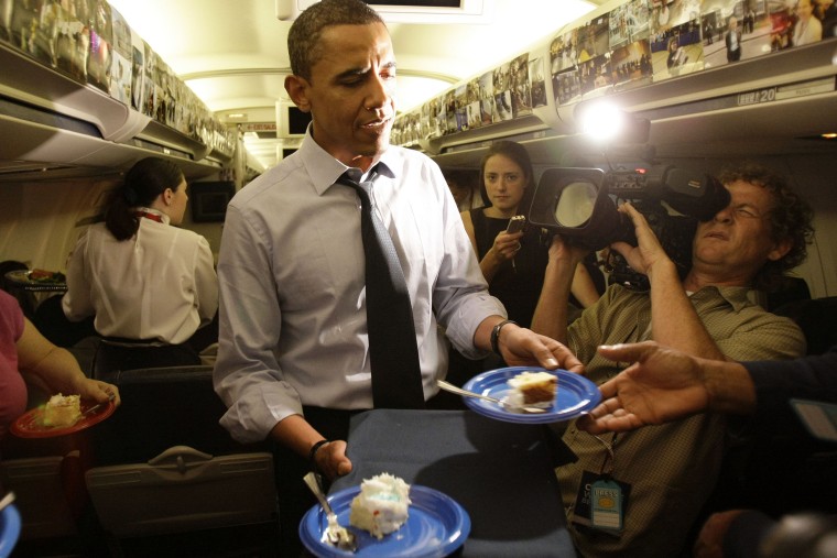 Then, Democratic presidential candidate Sen. Barack Obama, D-Ill., serves birthday cake to the press corps on his birthday while in flight, Aug. 4, 2008. (Photo by Alex Brandon/AP)