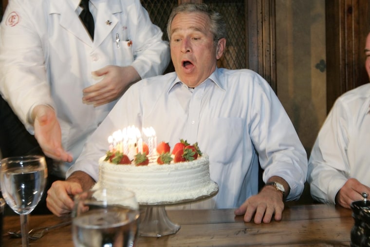 President Bush, left, prepares to blows out the candles on his birthday cake as he celebrates with Richard M. Daley, right, Mayor of Chicago, at the Chicago Firehouse restaurant, July 6, 2006 in Chicago. (Photo by Pablo Martinez Monsivais/AP)