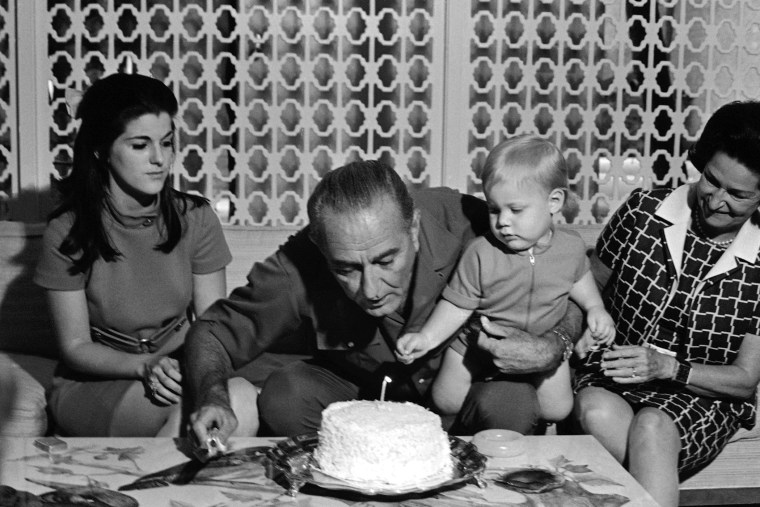 U.S. President Lyndon Johnson leans over to blow out candle on his birthday cake as his 14-month-old grandson, Patrick Lyndon Nugent eyes the procedure in home of their younger daughter Luci Johnson Nugent on Aug. 27, 1968 in Austin. (Photo by AP)
