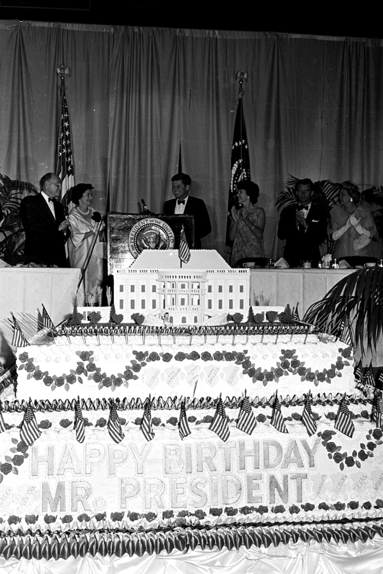 President John F. Kennedy arrives at the head table as he attends a $100-a-plate Democratic dinner in Washington's National Guard Armory, May 27, 1961, marking his 44th birthday, which is actually May 29. (Photo by AP)