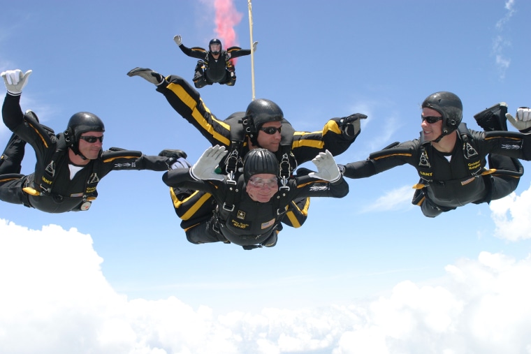 Former U.S. President George H.W. Bush (C, bottom) performs a tandem parachute jump with Army Golden Knight Sgt. Bryan Schnell on June 13, 2004 over the Bush Presidential Library in College Station, Texas. (Photo by U.S. Arm/Texas A&M University/Getty)