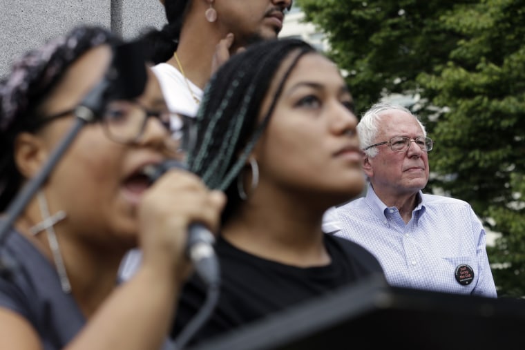 Marissa Johnson, left, speaks as Mara Jacqueline Willaford stands with her and Democratic presidential candidate Sen. Bernie Sanders, I-Vt., stands nearby as the two women take over the microphone at a rally Aug. 8, 2015, in Seattle (Elaine Thompson/AP)