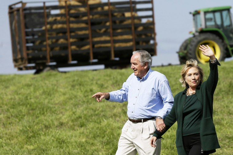 Former Secretary of State Hillary Rodham Clinton waves as she walks with U.S. Sen. Tom Harkin, left as they arrive at Harkin's annual fundraising Steak Fry, Sunday, Sept. 14, 2014, in Indianola, Iowa. (Photo by Charlie Neibergall/AP)