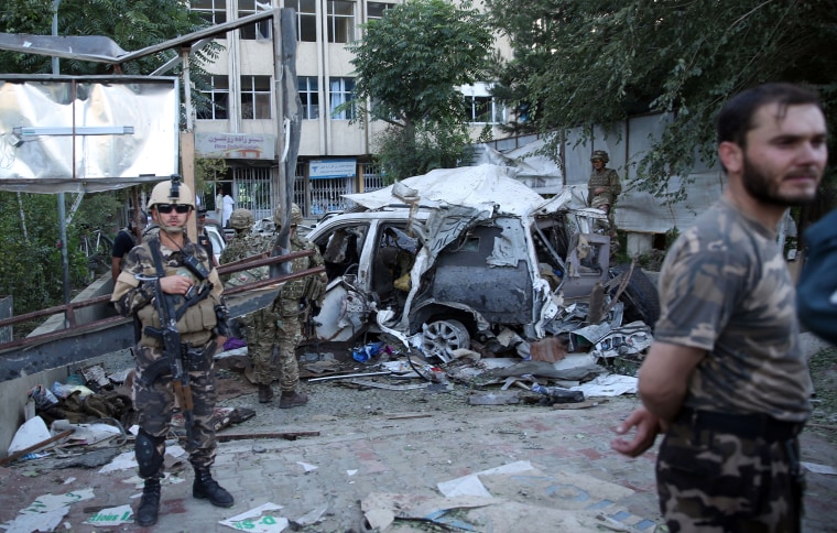 Afghan security forces and British soldiers inspect the site of a suicide attack in Kabul, Afghanistan, Aug. 22, 2015. The bomber attacked a NATO convoy, killing at least 10 people, including three NATO contractors. (Photo by Massoud Hossaini/AP)
