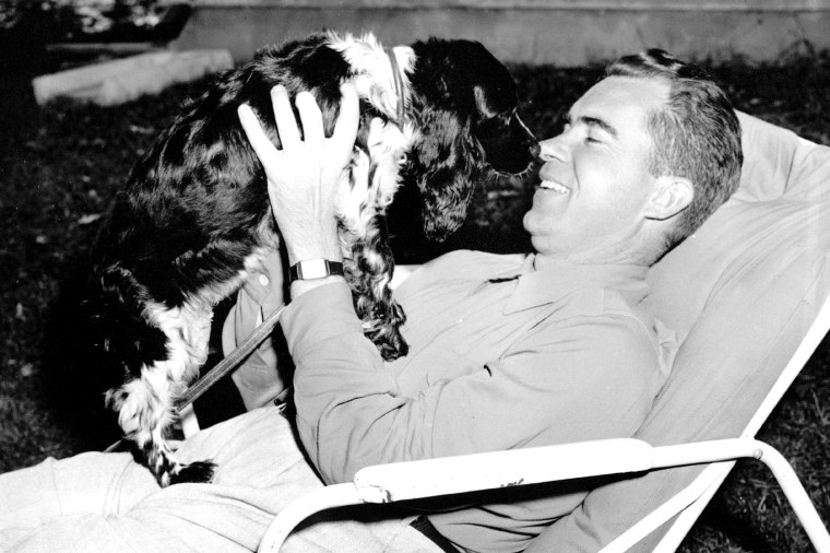 Richard M. Nixon fondled family's black and white cocker spaniel \"Checkers\" at his home in Washington on September 28, 1952. (Photo by AP)