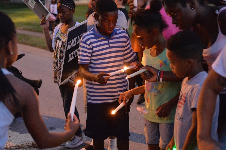 Children gather at the Michael Brown Jr. memorial on Canfield Drive during a candlelight vigil held in honor of Jamyla Bolden on August 20, 2015 in Ferguson, Missouri. (Photo by Michael B. Thomas/Getty)