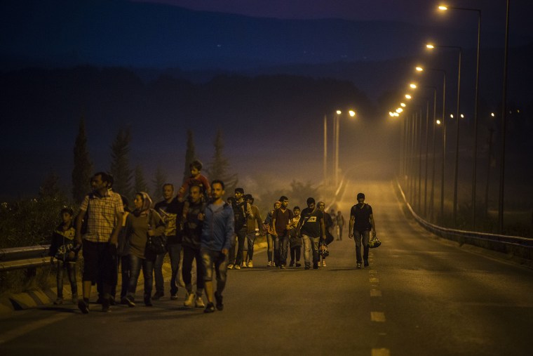 Syrian refugees walk along the roads of the border town of Idomeni, northern Greece to cross the border and enter Macedonia, on Aug. 25, 2015. (Photo by Santi Palacios/AP)