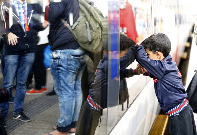 A young boy leans against the carriage of a train as migrants disembark at a railway station in Vienna, Austria, Sep. 5, 2015, as thousands of exhausted migrants streamed into Austria from Hungary. (Photo by Dominic Ebenbichler/Reuters)