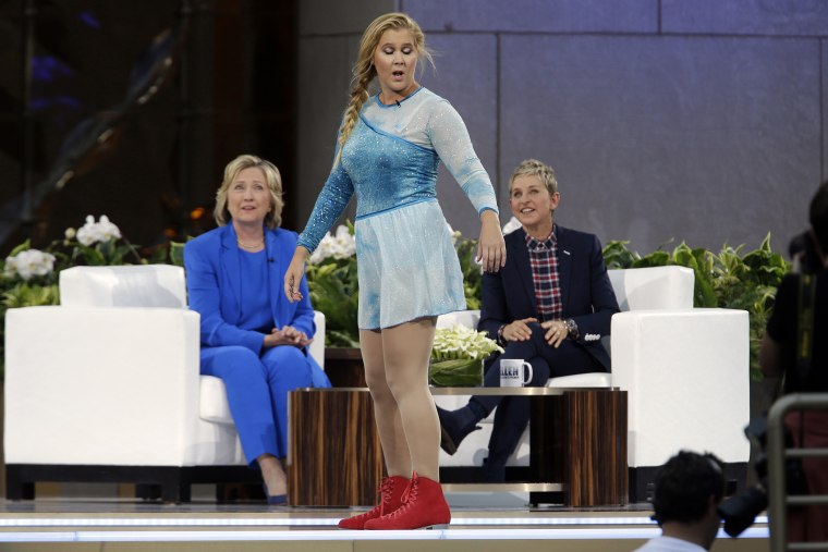 Actress Amy Schumer, center, skates past Democratic presidential candidate Hillary Rodham Clinton as she speaks to Ellen DeGeneres during a taping of The Ellen DeGeneres Show, Tuesday, Sept. 8, 2015, at Rockefeller Center, NY. (Photo by Mary Altaffer/AP)
