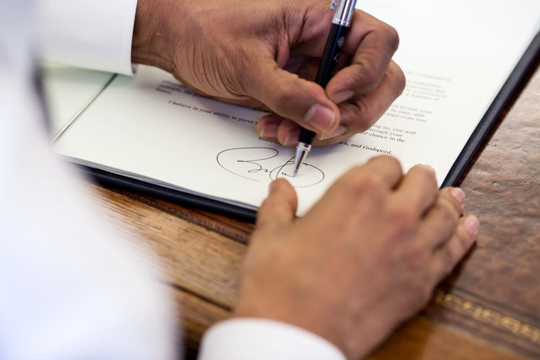 President Barack Obama signs commutation letters in the Oval Office, March 31, 2015. (Photo by Pete Souza/White House)