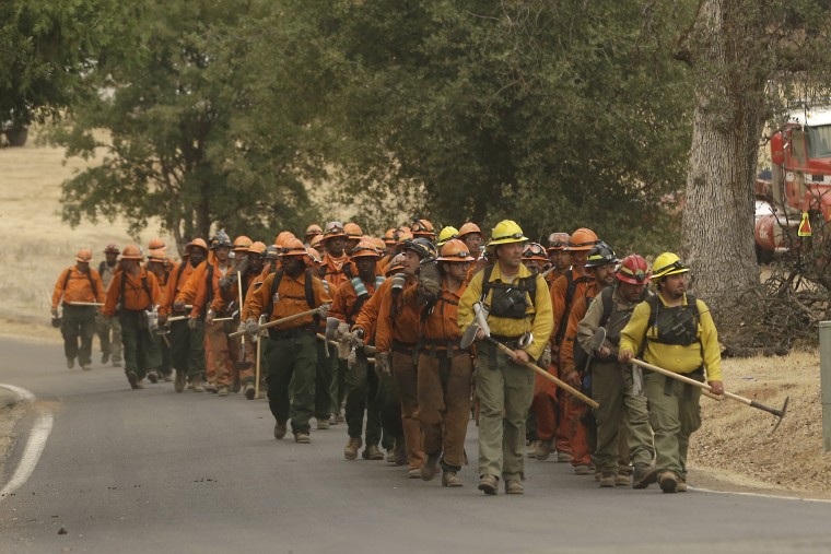 A California Department of Corrections and Rehabilitation inmate work crew walks through Sheep Ranch, Calif., on the way to battle a fire, Sept. 13, 2015. (Photo by Rich Pedroncelli/AP)