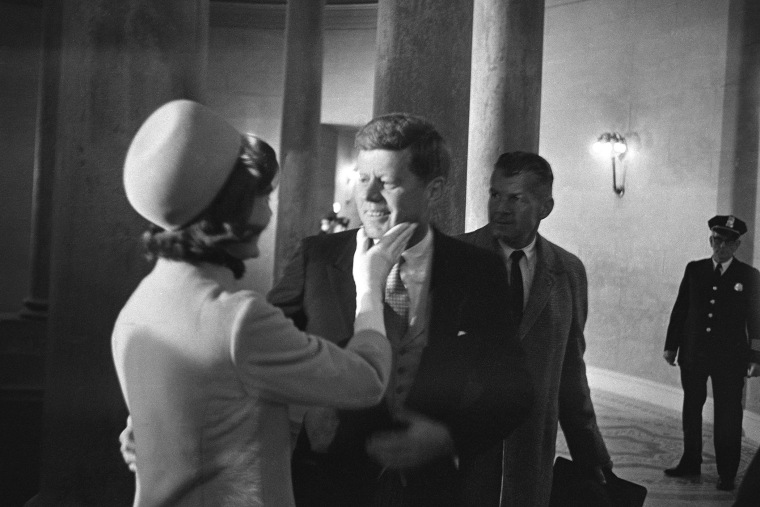 In this Jan. 20, 1961 file photo, Jacqueline Kennedy, left, places her hand under the chin for her husband, President John F. Kennedy, moments after he became president. (Photo by Henry Burroughs/AP)