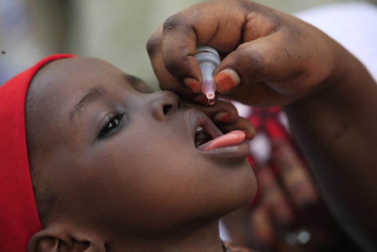 A health official administers a polio vaccine to a child in Kawo Kano, Nigeria, April 13, 2014. (Photo by Sunday Alamba/AP)