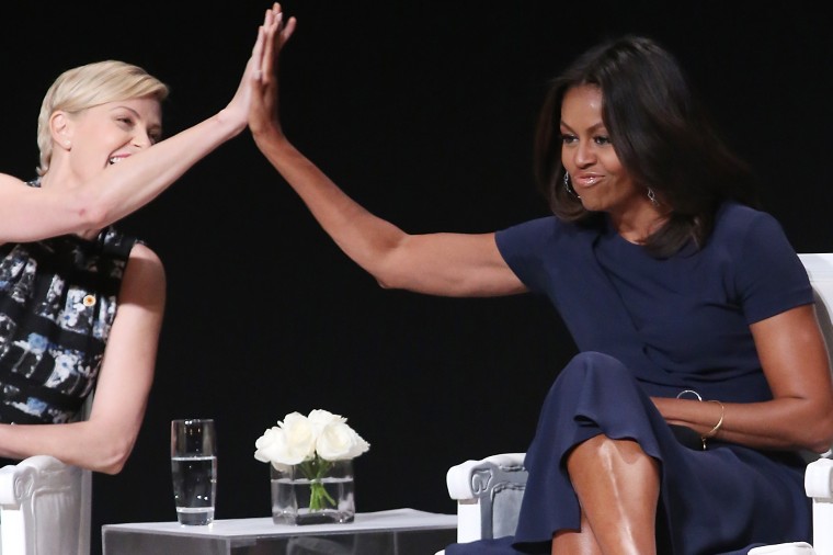 First Lady Michelle Obama receives a high five from actress Charlize Theron during the \"Let Girls Learn\" Global Conversation at The Apollo Theater on Sept. 29, 2015 in New York City. (Photo by Bennett Raglin/WireImage/Getty)