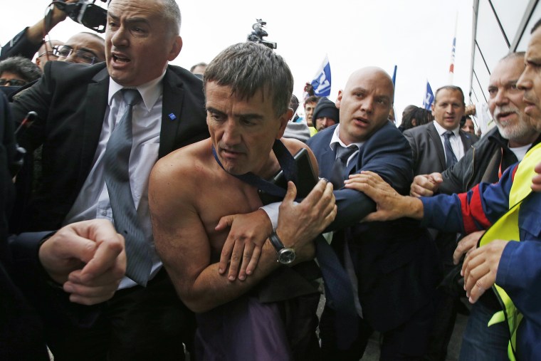 A shirtless Xavier Broseta (2ndL), Executive Vice President for Human Resources and Labour Relations at Air France, is evacuated by security after employees stormed into a meeting at the Air France headquarters in Roissy. (Photo by Jacky Naegelen/Reuters)