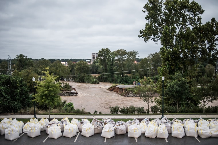 Flood waters rush through the breach of the Columbia Canal as emergency workers prepare giant sandbags to plug the hole on Oct. 5, 2015 in Columbia, S.C. (Photo by Sean Rayford/Getty)