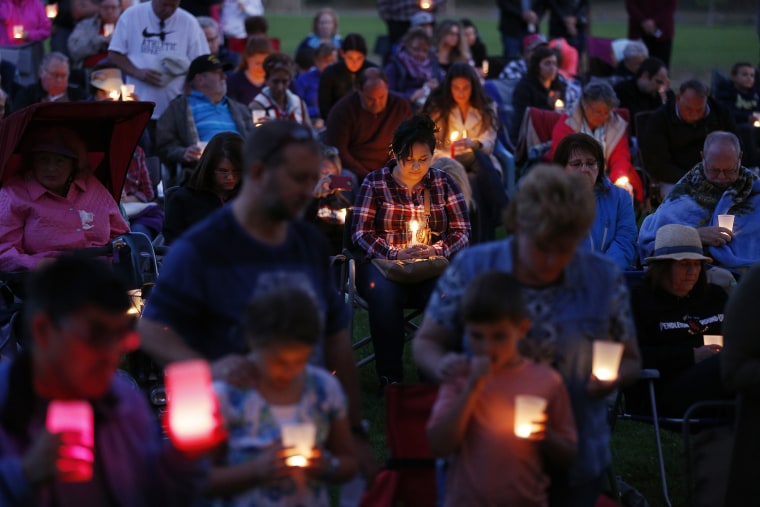 People bow their heads in prayer during a vigil held in honor of the victims of the fatal shooting at Umpqua Community College, Oct. 3, 2015, in Winston, Ore. (Photo by John Locher/AP)