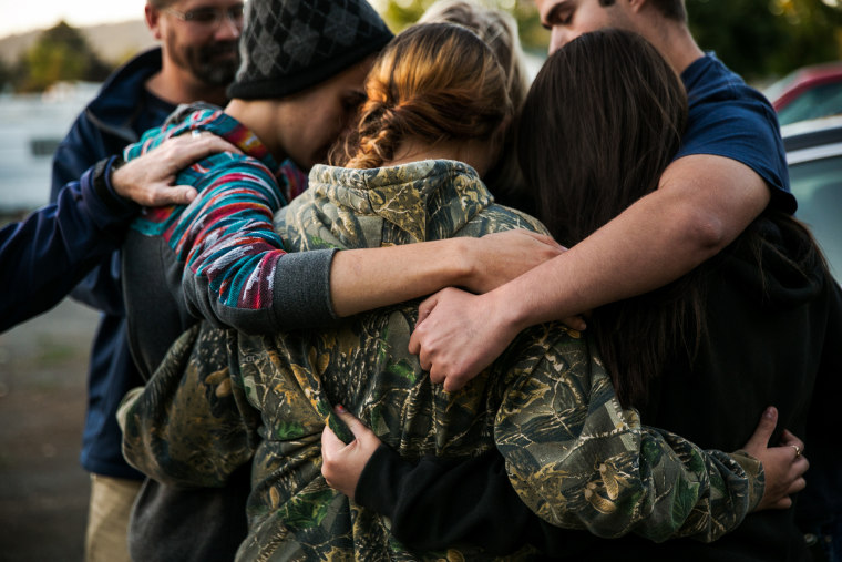 Friends of the late Rebecka Ann Carnes, an Umpqua Community College mass shootings victim, embrace one another in prayer during a memorial service in Winston, Ore., Oct. 3, 2015. (Photo by Marcus Yam/Los Angeles Times/Getty)