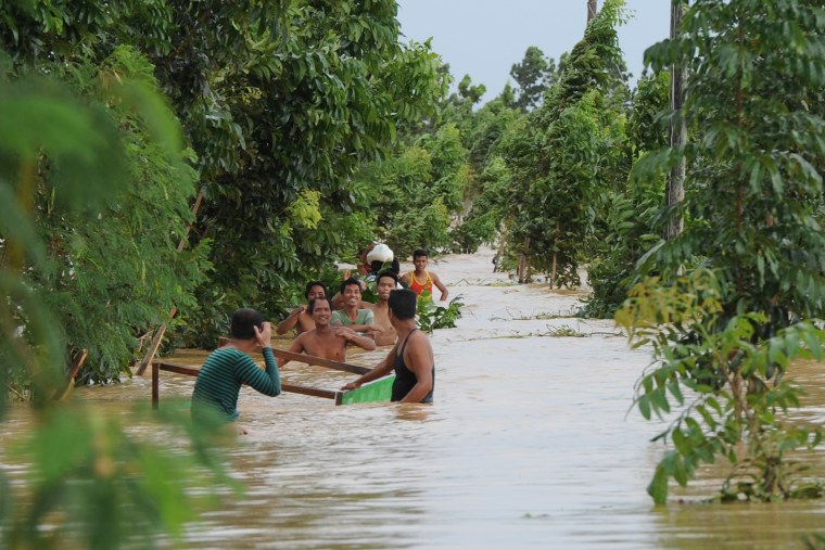 Residents wade through floodwaters brought on by heavy rains caused by Typhoon Koppu in the town of Santa Rosa, Nueva Ecija province, north of Manila on Oct. 19, 2015, a day after Typhoon Koppu hit the province of Aurora. (Photo by Ted Aljibe/AFP/Getty)