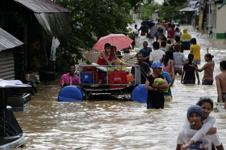 Filipino typhoon victims wade in flood waters in Cabanatuan city, northern Manila, Philippines, on Oct. 19, 2015. (Photo by Francis R. Malasig/EPA)