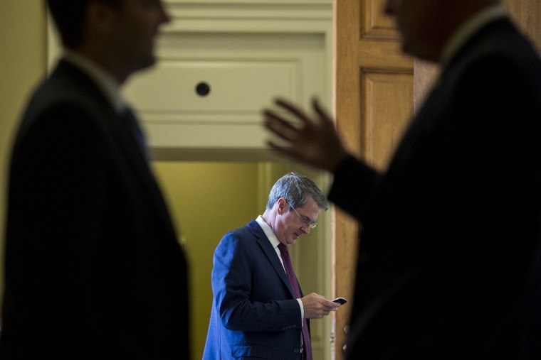 Sen. David Vitter, R-La., center, talks on his cell phone as two Senators in the foreground talk outside of the Senate Republicans' policy lunch in the Capitol on April 21, 2015 in Washington, D.C. (Photo By Bill Clark/CQ Roll Call/Getty)