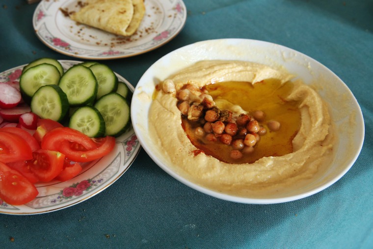 Plates of hummus, fresh vegetables and home-made bread. (Photo by Sean Gallup/Getty)