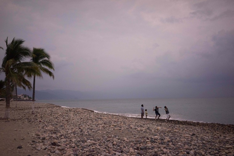People throw stones into the ocean as hurricane Patricia nears in the Pacific resort city of Puerto Vallarta, Mexico, Oct. 22, 2015. (Photo by Cesar Rodriguez/AP)
