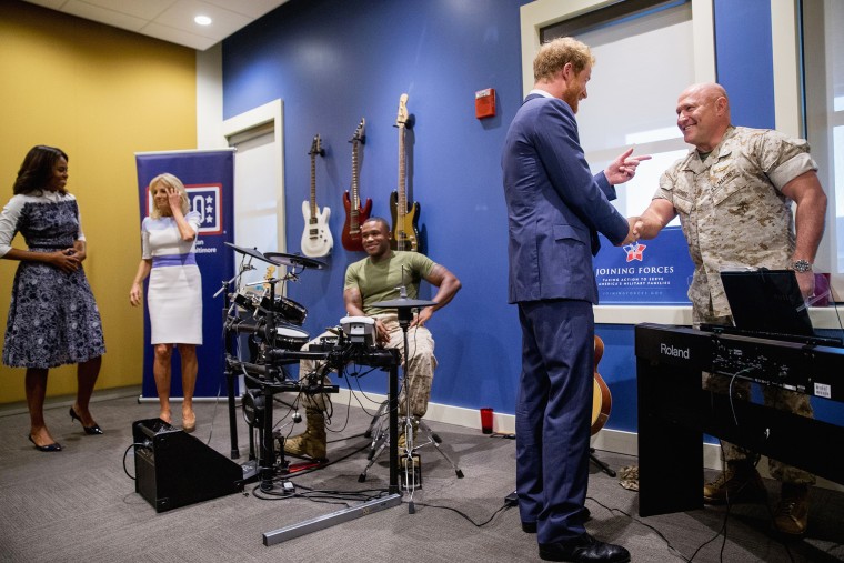 Britain's Prince Harry, accompanied by first lady Michelle Obama, Jill Biden, and Marine Sgt. Roderic Liggens of Washington, tours the USO Warrior and Family Center, Oct. 28, 2015 in Fort Belvoir, Va. (Photo by Andrew Harnik/AP)